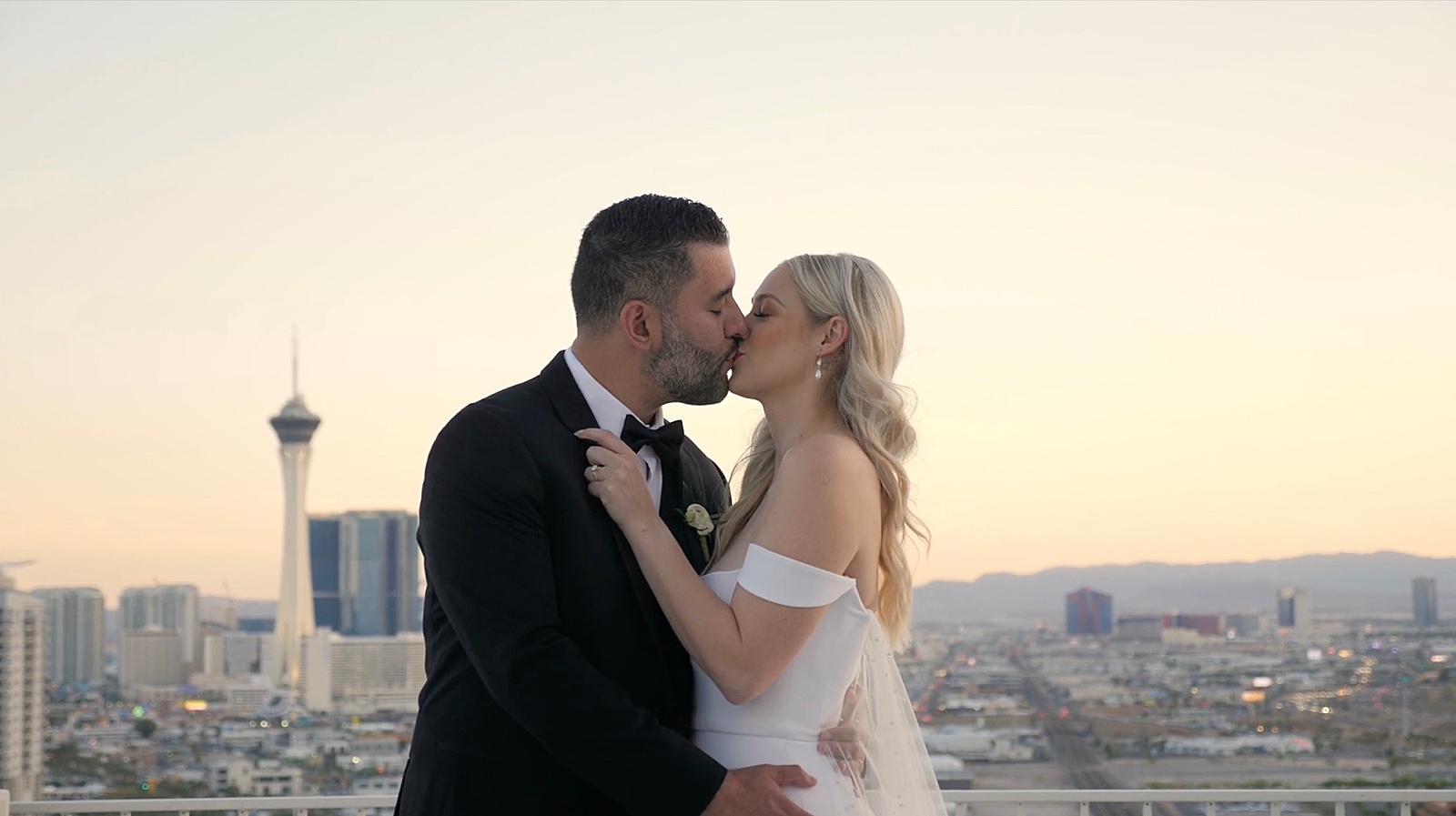 Bride and groom kiss on a rooftop during golden hour
