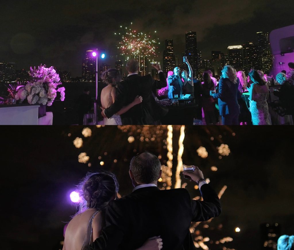 Bride and groom watch a fireworks show with their guests by Cydne Robinson Films